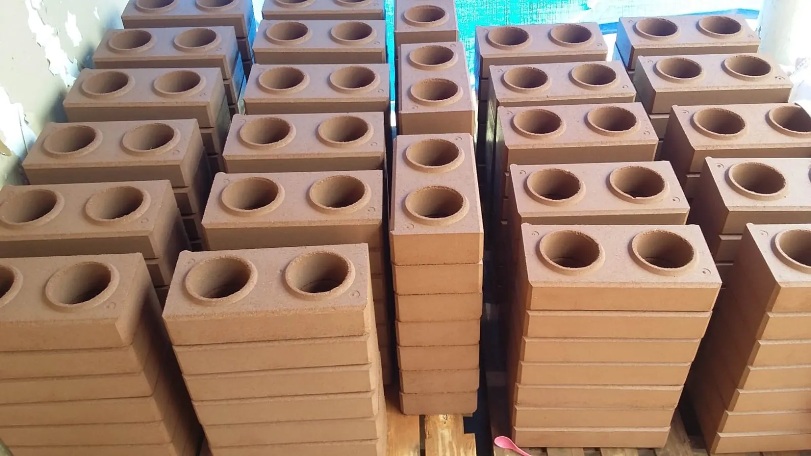 Pilas de ladrillos ecológicos color terracota, apilados con sus dos orificios hacia arriba