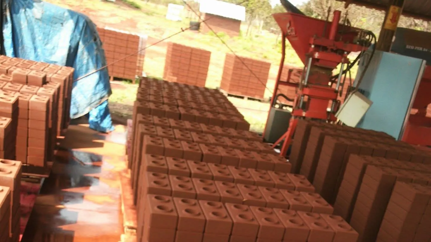 Ladrillos terracota apilados en la planta, junto a la prensa