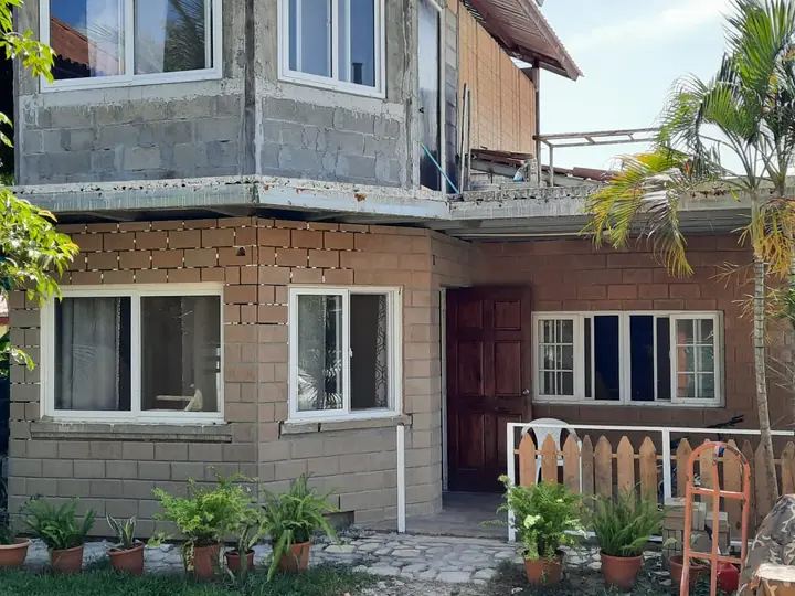 Casa con la planta baja forrada en ladrillo y revestimiento ecológico