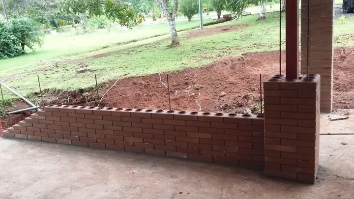 Muro largo de ladrillo ecológico que termina en una columna