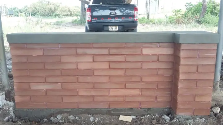 Muro de ladrillo ecológico terracota terminado con tapa de concreto y una columna al extremo